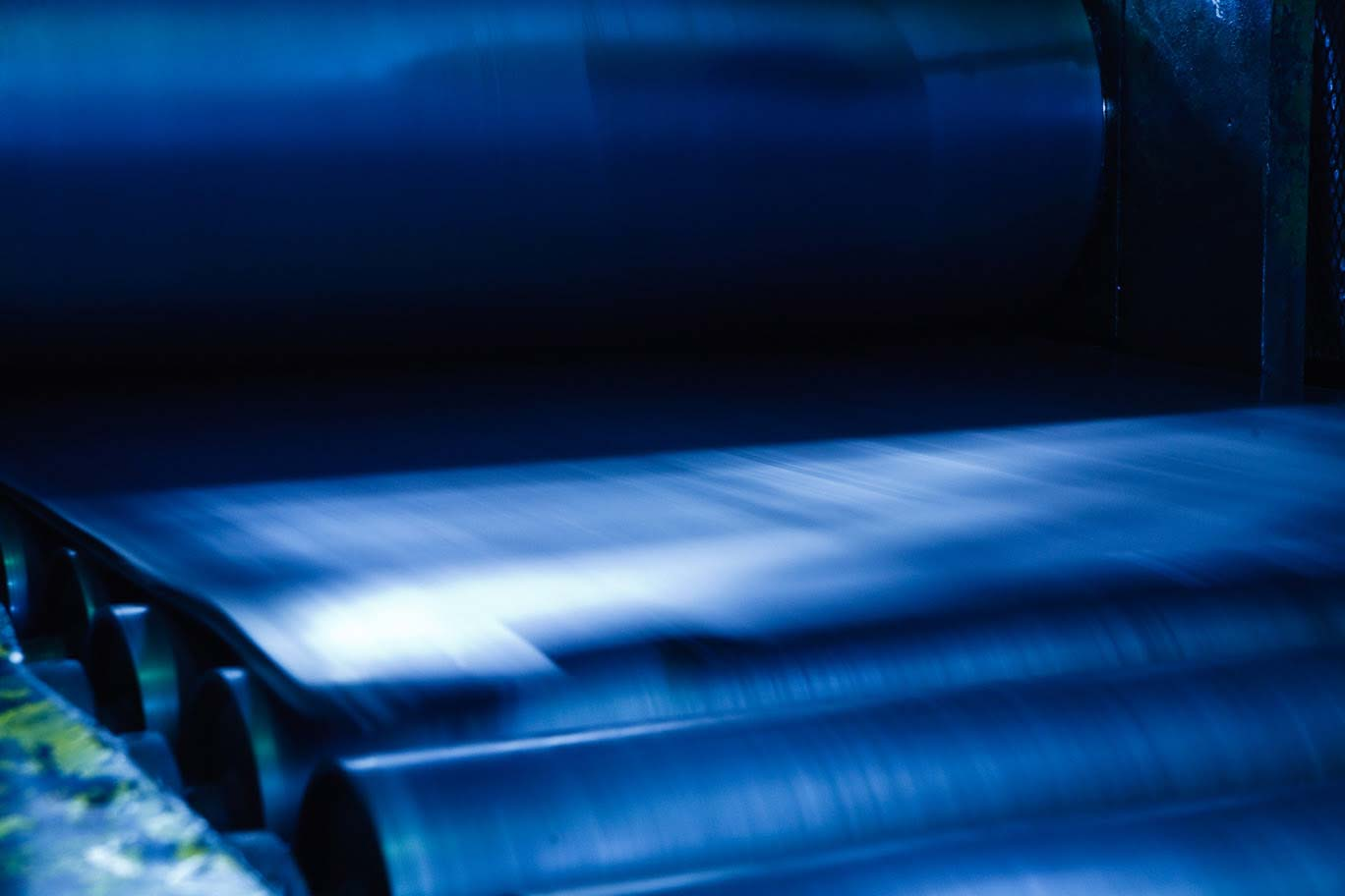 Stack of curved metal sheet panels lit in blue tones